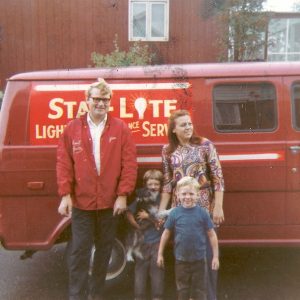 Jim, Joanne, Scott, and Chris holding Heidi in front of the first service truck.